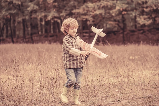 Happy child playing outdoors Happy boy play airplane Little boy with plane