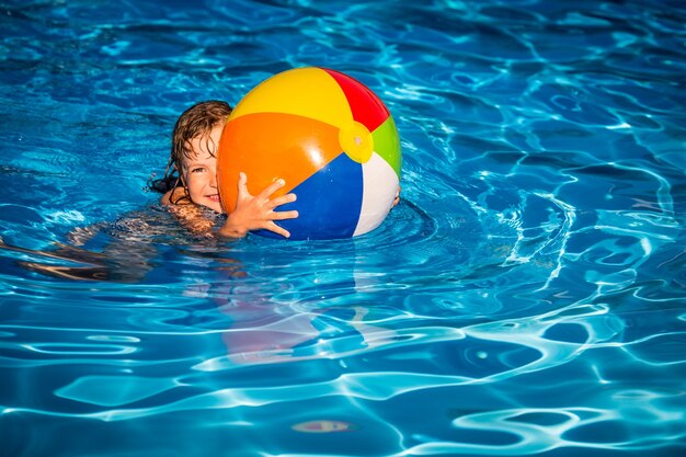 Happy child playing in swimming pool