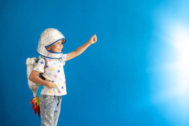 Photo happy child pretend to be astronaut portrait of kid against blue background