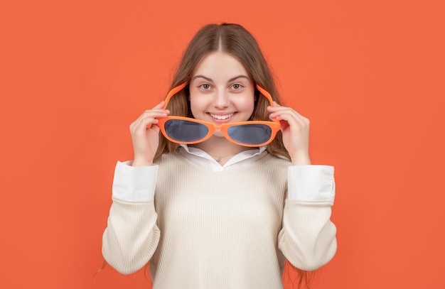 Happy child smiling looking over big funny glasses brown background childhood