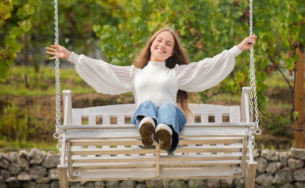 Photo happy child swinging on swing outdoor, summer.