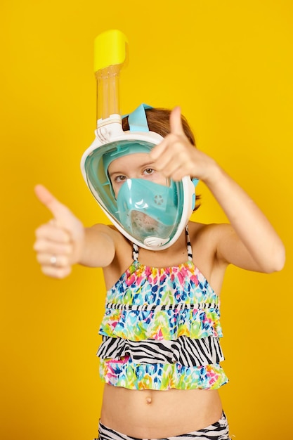 Happy child teenager girl with in swimsuit and snorkeling mask in studio