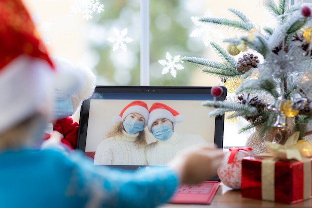 Happy child wearing medical mask Father and mother greeting in video chat