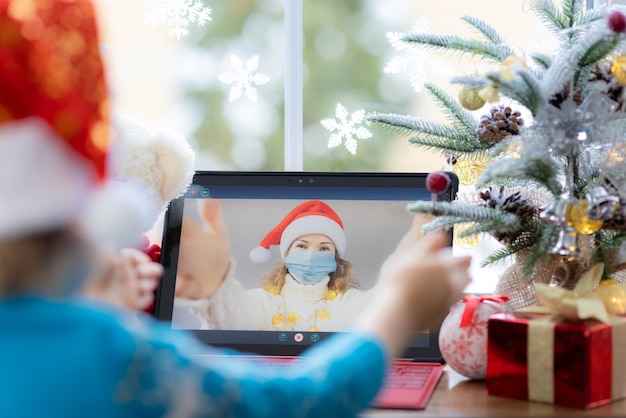 Happy child wearing medical mask Mother greeting in video chat