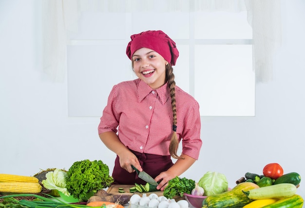 Happy child with colorful vegetables in kitchen healthy food