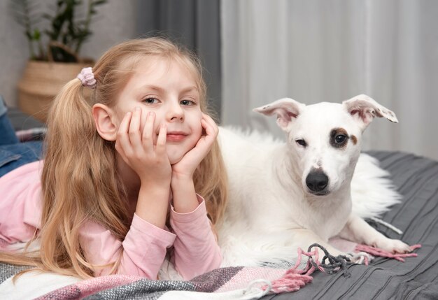 Happy child with dog. Portrait girl with pet. Girl and white Jack Russell