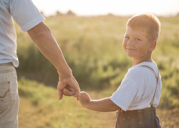 Happy child with Grandfather playing at the meadow