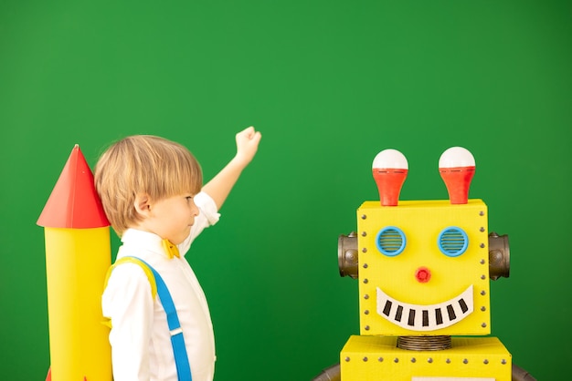 Happy child with toy robot in class