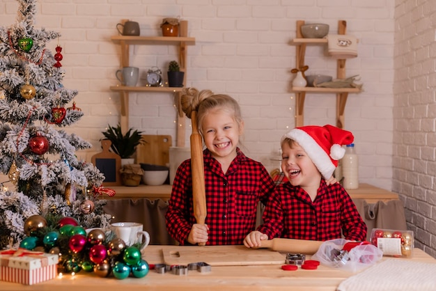 happy children bake Christmas cookies at home in the kitchen