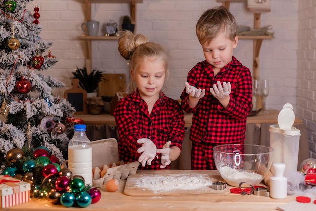 happy children bake Christmas cookies at home in the kitchen