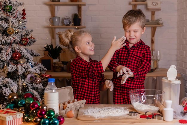 happy children bake Christmas cookies at home in the kitchen