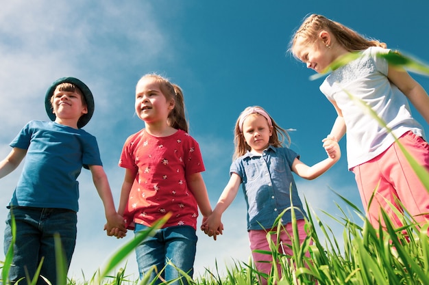 Happy children of boys and girls run in the Park on the grass on a Sunny summer day 