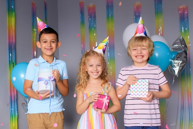 Happy children have fun during the holidays and jump in colorful confetti