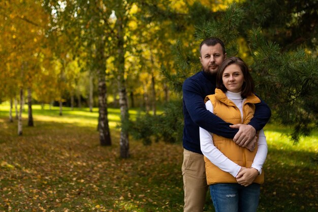 Happy classic traditional family hugging against autumn forest background