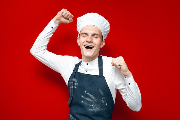 Happy cook rejoice in victory on red isolated background guy in chef uniform is winner