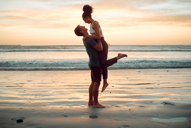 Happy couple at beach hug and love celebration on romantic sunset tropical ocean water hawaii luxury vacation travel or holiday Woman and man dating and celebration for engagement announcement