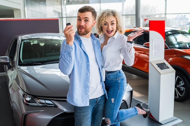 Happy couple in car dealership