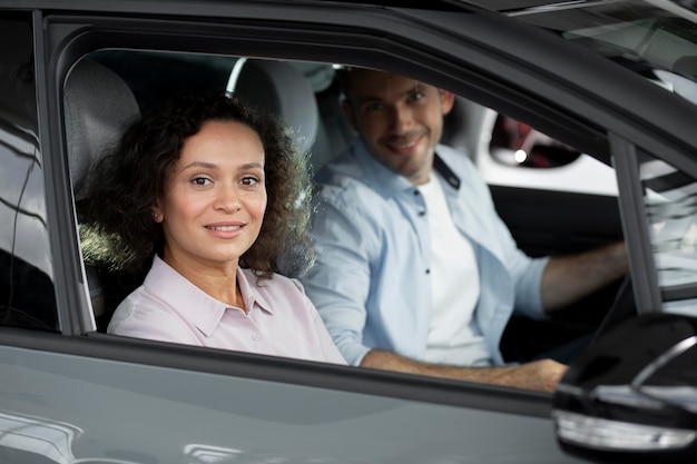 Happy couple in car showroom dealership