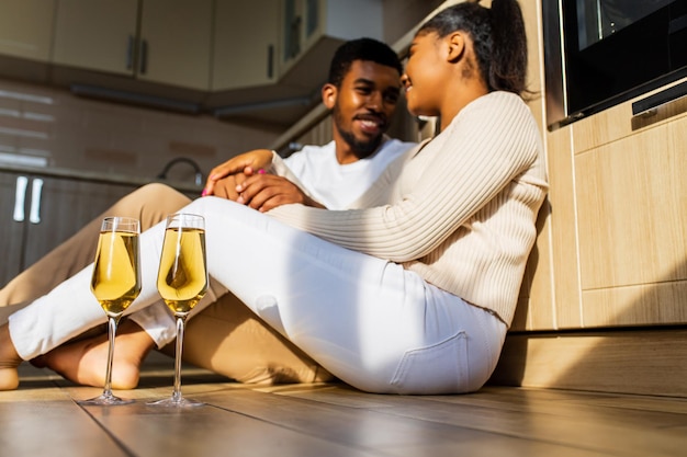 Happy couple celebrating anniversary while sitting at the warm floor in kitchen