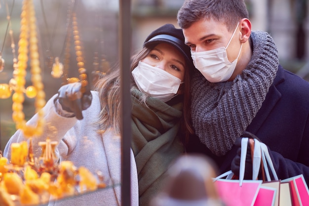 Happy couple celebrating Valentines Day in masks during covid-19 pandemic in the city