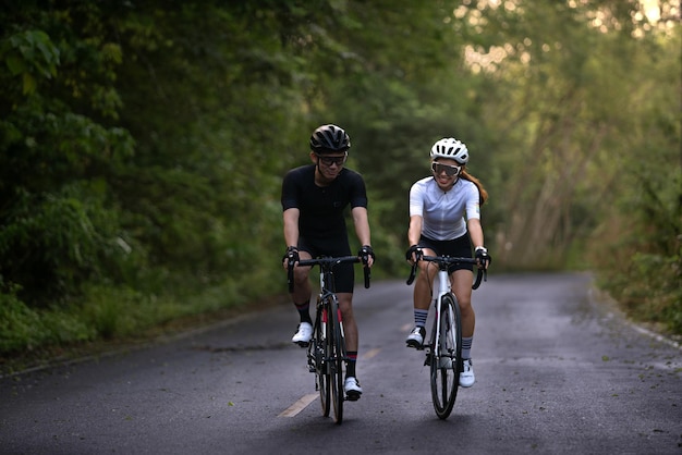 Happy couple cycle or ride bicycle on rode in countryside for health life style