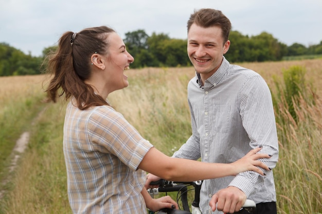 The happy couple cycling near the field