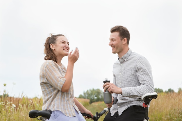 The happy couple cycling near the field