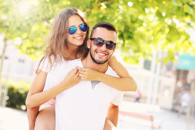 a happy couple doing piggyback in the park