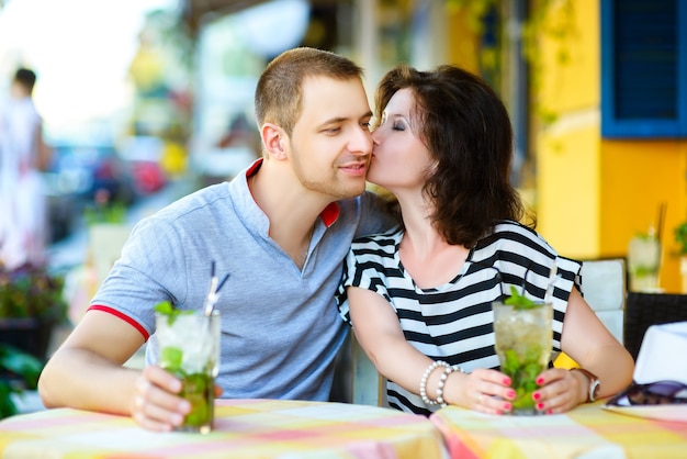 Happy couple drinking lemonade in an outside cafe.