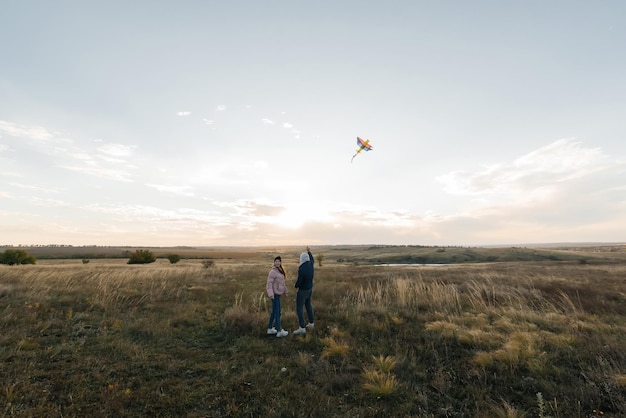 A happy couple flies a kite and spends time together outdoors in a nature reserve Happy relationships and family vacations Freedom and space