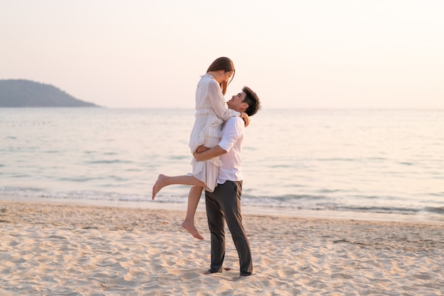 Happy couple going honeymoon travel on tropical sand beach in summer