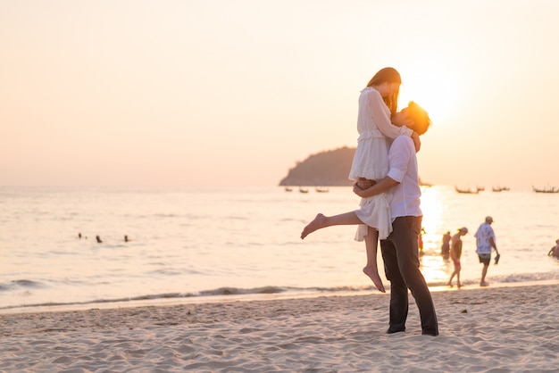 Happy couple going honeymoon travel on tropical sand beach in summer