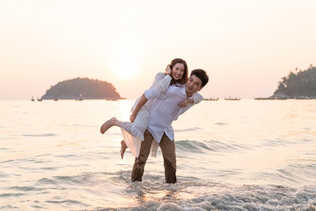 Happy couple going honeymoon travel on tropical sand beach in summer