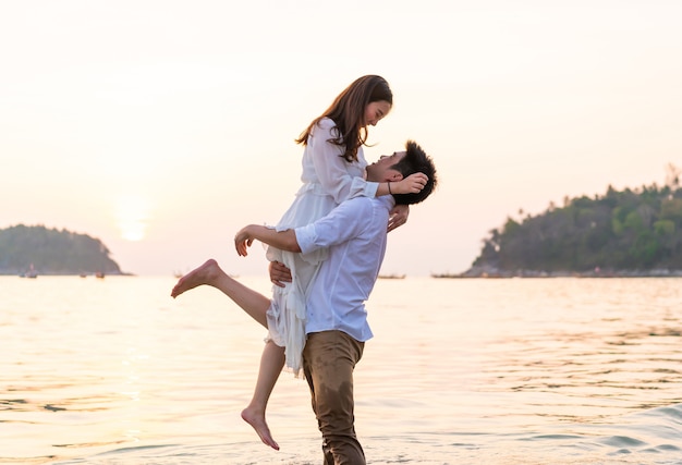 Happy couple going honeymoon travel on tropical sand beach in summer