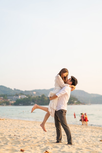 Happy couple going on honeymoon travel on tropical sand beach in summer