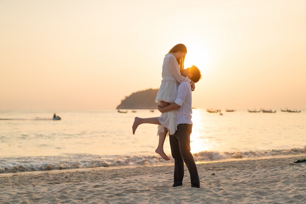 Happy couple going honeymoon travel on tropical sand beach in summer