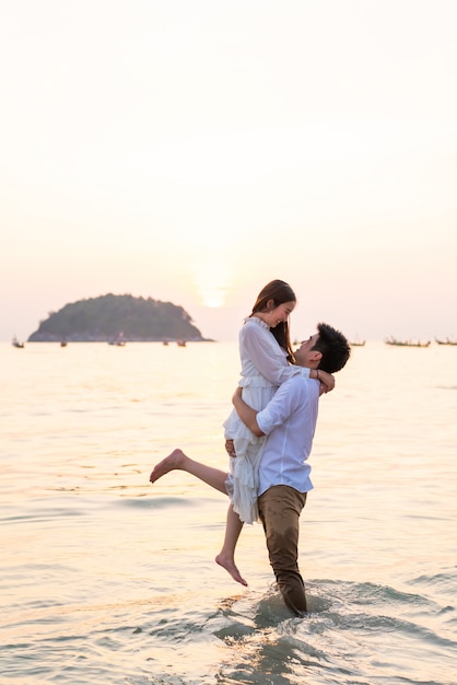 Happy couple going honeymoon travel on tropical sand beach in summer