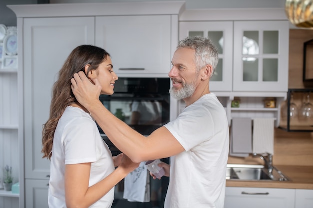 Happy couple. A grey-haired man hugging his beautiful young wife