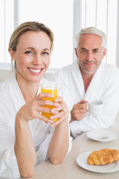 Happy couple having breakfast in bathrobes 