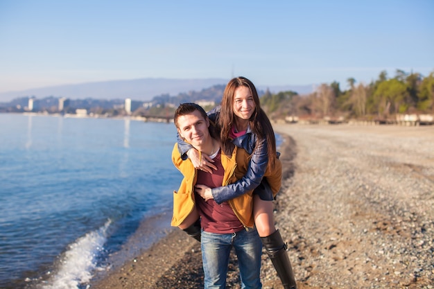 Happy couple having fun at the beach on a sunny winter day