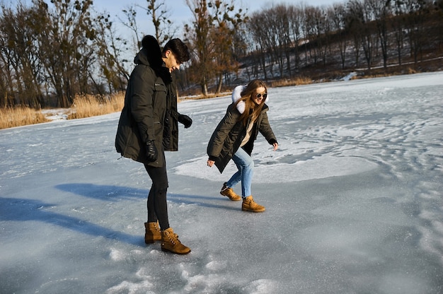 Happy couple hugging and laughing outdoors in winter