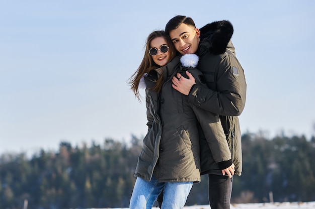 Happy couple hugging and laughing outdoors in winter.