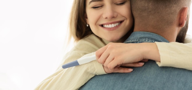 Happy Couple Hugging With Positive Pregnancy Test