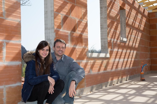 Happy couple inside their new home still under construction