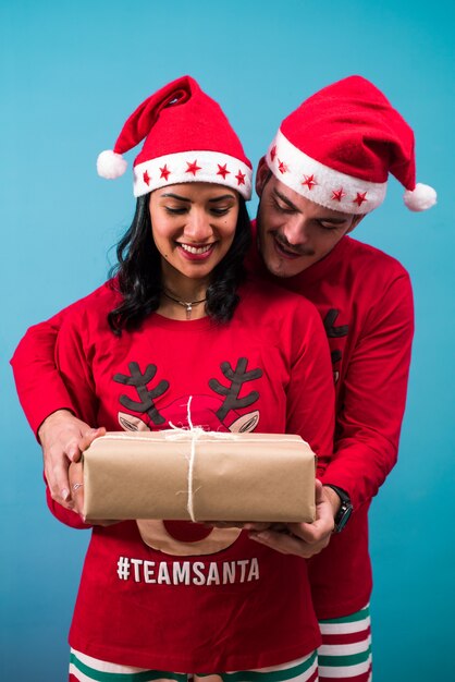 Photo happy couple looking at a christmas present they have in their hands