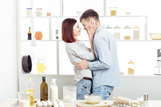 Happy Couple in love cooking dough and kissing in the kitchen