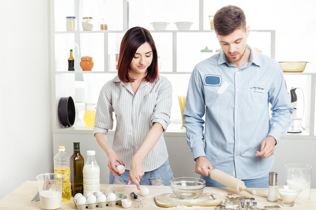 Happy Couple in love cooking dough in the kitchen