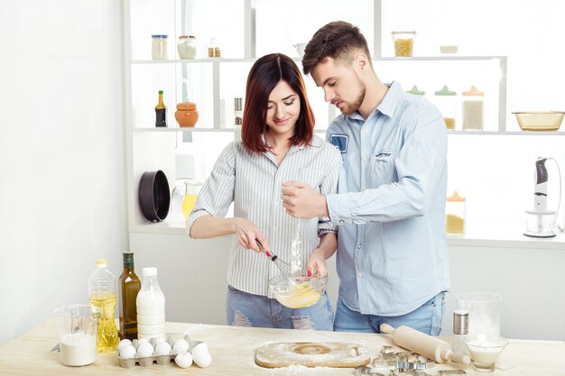 Happy Couple in love cooking dough in the kitchen