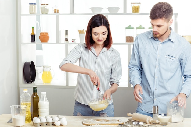 Happy Couple in love cooking dough in the kitchen