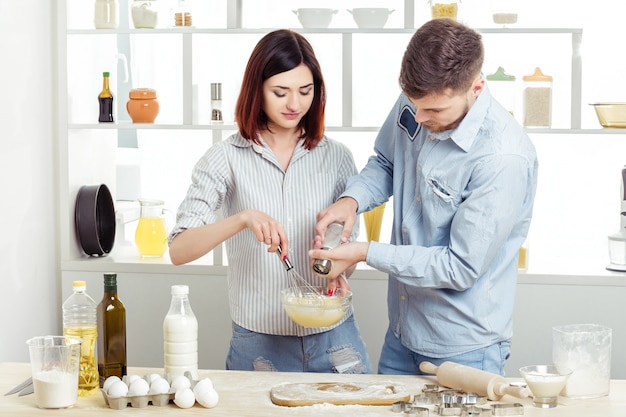 Happy Couple in love cooking dough in the kitchen